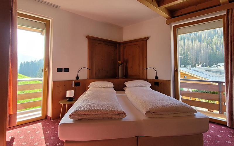 Doppelzimmer aus Zirbenholz im Garni Royal in Arabba mit Balkon und Dolomitenblick.