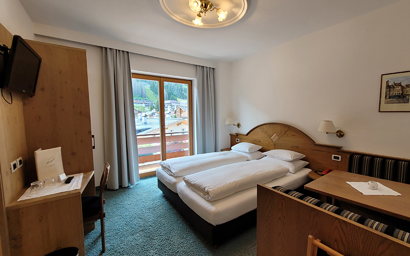 Doppelzimmer im Garni Royal in Arabba mit Einzelbetten, eigenem Balkon und Blick auf die Dolomiten.