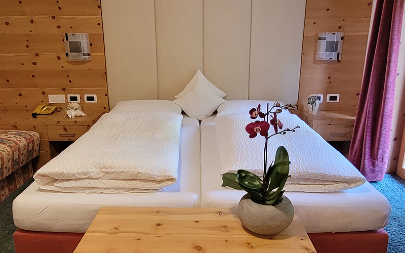 Küche und Essbereich eines Chalet Royal Apartments in Arabba, mit hellen Holzmöbeln und sichtbaren Balken.