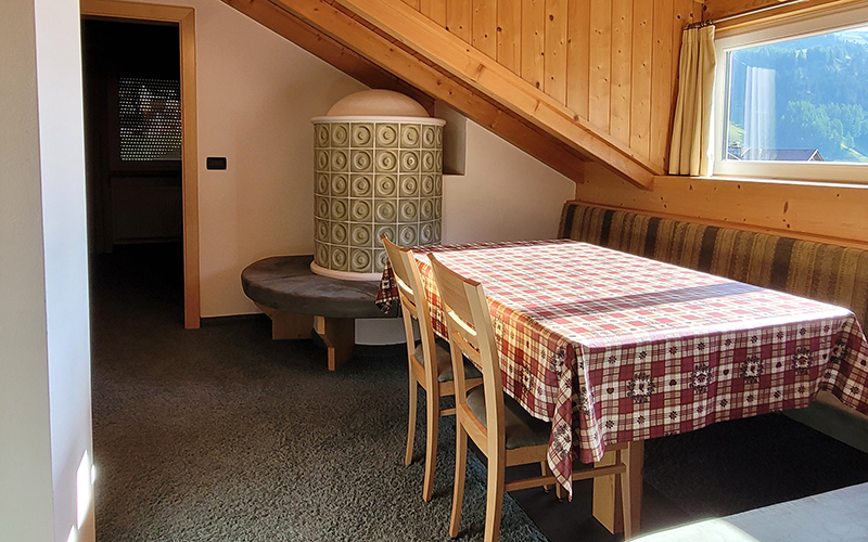 Double room at Garni Royal in Arabba with separate beds, wooden floor, and pine wood wall.