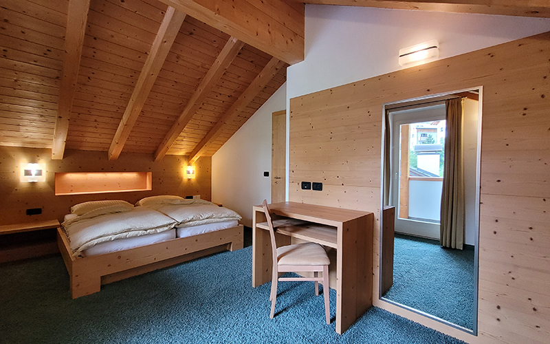 Interior of a Chalet Royal apartment in Arabba with a dining table, sofa, and bathroom access.