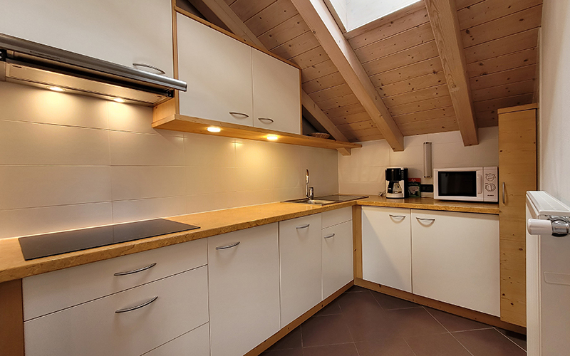 Light wooden double bedroom in the Chalet Royal in Arabba, with exposed beam ceiling.